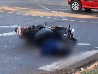 Corpo de vigia caído ao lado da moto, no centro de Ponta Porã. (Foto: Direto das Ruas)