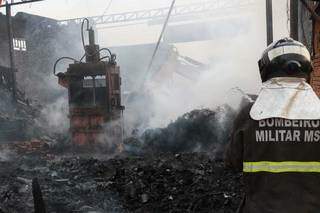 Retroescavedeira e 40 mil litros de &aacute;gua s&atilde;o usados em inc&ecirc;ndio de dep&oacute;sito