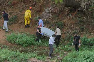 Corpo sendo retirado do local onde foi encontrado, no Rio Anhanduí, nesta manhã. (Foto: Marcos Maluf)