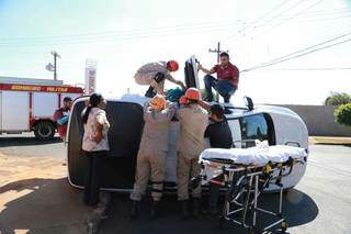 Equipe do Corpo de Bombeiros durante retirada de idosa do veículo tombado. (Foto: Kísie Ainoã)