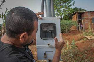 Consumidor olha para relógio de energia em Campo Grande. (Foto: Marcos Maluf)