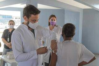 Profissional de saúde aplica vacina em idosa durante ação itinerante no Terminal Bandeirantes. (Foto: Marcos Maluf)