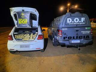 Veículo carregado com as drogas ao lado de viatura do DOF. (Foto: DOF) 