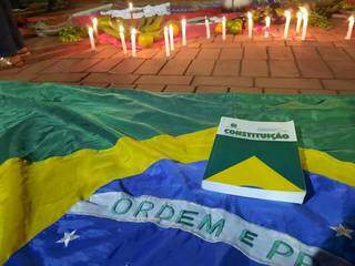 Exemplar da constituição sobre a bandeira do Brasil. (Foto: Caroline Maldonado)