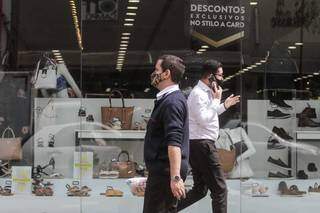 Homens, de máscara, caminham pelo Centro de Campo Grande. (Foto: Marcos Maluf)