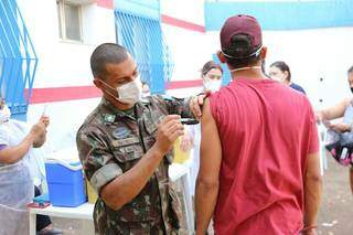 Morador recebe vacina em ponto d eimunização itinerante montado em Campo Grande. (Foto: Paulo Francis)