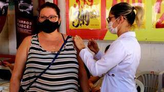 Mulher recebe dose da vacina em supermercado da Capital. (Foto: PMCG)
