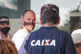 Servidor auxiliando clientes na fila em um das agência da Caixa em Campo Grande (Foto: arquivo/Campo Grande News) 
