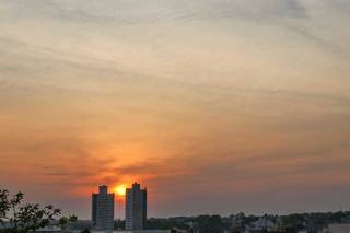 Sol aparece entre prédios na região do Bairro Santa Fé, na Capital. (Foto: Henrique Kawaminami)