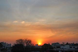 Vista do sol nascendo de quem passa pela Avenida Fernando Corrêa da Costa, na Capital. (Foto: Henrique Kawaminami)