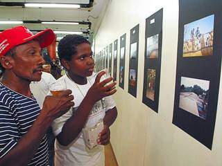 Na foto, está Maurílio, aos 13 anos, e o pai contemplando a exposição de fotos realizada por ele e outros amigos. (Foto: Elis Regina e Vânia Jucá)