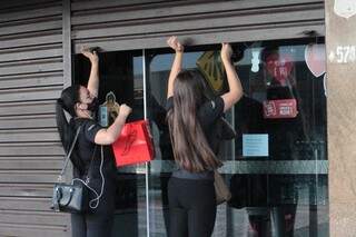 Trabalhadoras levantam porta de estabelecimento comercial na Capital. (Foto: Marcos Maluf/Arquivo)