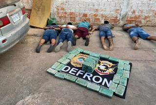Traficantes deitados no chão diante da droga avaliada em R$ 650 mil. (Foto: Divulgação)