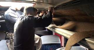 Policiais serrando o compartimento do ônibus onde foi encontrada a cocaína. (Foto: PRF) 