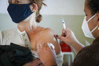 Mulher recebe dose de vacina contra a covid-19 em Campo Grande (Foto: Henrique Kawaminami/Arquivo)