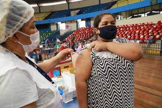 Profissional de saúde aplica dose em mulher no Guanandizão. (Foto: Kísie Ainoã)