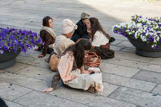 Maria Emília, de lenço na cabeça, sentada em meio a outros figurantes. (Foto: Arquivo Pessoal)