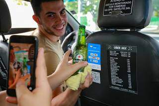 Paulo Henrique estacionado, entregando bebida ao passageiro. (Foto: Kísie Ainoã)