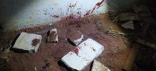 Manchas de sangue em pedras e na parede da casa. (Foto: Perfil News)
