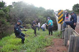 Policiais e equipe da funerária fazendo a retirada do corpo do local. (Foto: Paulo Francis)
