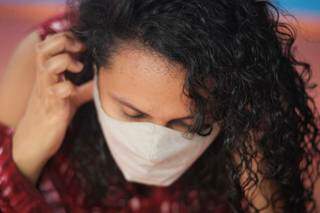 Mulher coloca máscara, que continua reduzindo chance de infecção pelo coronavírus (Foto: Marcos Maluf)