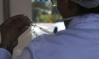 Trabalhadora da saúde com dose da vacina contra a covid-19 em mãos. (Foto: Fabio Rodrigues Pozzebom/Agência Brasil) 