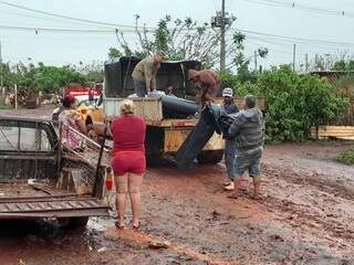 Equipe da prefeitura entrega lona para família que teve casa destelhada em Dourados. (Foto: Divulgação)