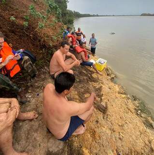 Sobreviventes às margens do Rio Paraguai após o acidente (Foto: Direto das ruas)