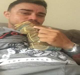Luciano de Souza Barbosa, conhecido como “Pequinês”, de 36 anos, com maços de dinheiro. (Foto: Direto das Ruas)