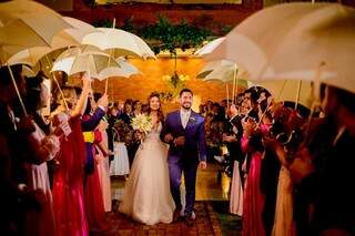 Padrinhos com guarda-chuvas para receber o casal, que teve festa dos sonhos. (Foto: To Studio Fotografia)