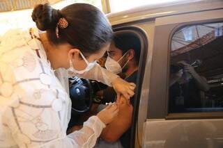 Profissional de saúde aplica vacina em motorista em drive-thru da Capital. (Foto: Kísie Ainoã/Arquivo)