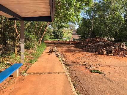 Com ponte interditada, morador passa por córrego para conseguir pegar ônibus