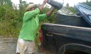 Produtor rural Almir Sandim abastecendo uma caixa d&#39;água com água do rio. (Foto: Reprodução)