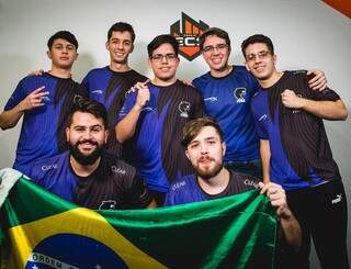 Membros da equipe FURIA reunidos e segurando uma bandeira do Brasil. (Foto: Divulgação/ECS)