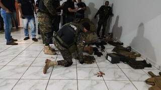Policial paraguaio separa munições encontradas em bunker de pistoleiros. (Foto: Divulgação)