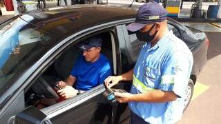 Carlos Eduardo, 42, paga pelo combustível que colocou no tanque do carro nesta manhã. (Foto: Cleber Gellio)