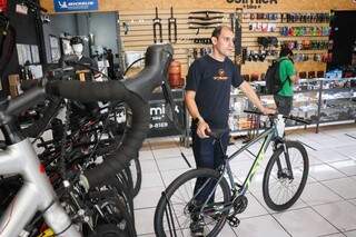 Roda aro 29 e lojista mostrando bike recomendada para quem quer começar a pedalar de casa ao trabalho. (Foto: Henrique Kawaminami)