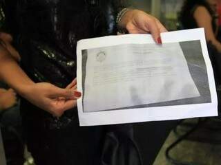Uma das candidatos que fez denúncia de vazamento mostra foto contendo texto da prova de digitação de 2018 (Foto: Marina Pacheco/Arquivo)