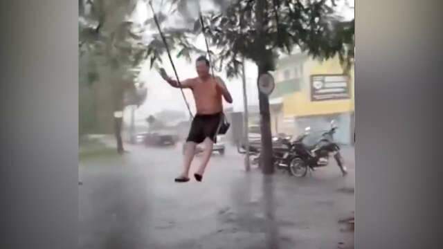 Feliz da vida, homem curte chuva em balan&ccedil;o na Av. Presidente Vargas