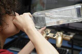 Adolescente bebe vodka direto da garrafa ao jogar video game. (Foto: Reprodução)