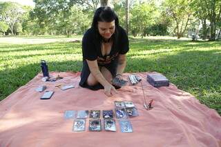 Regina abrindo as cartas no Bosque da Paz. (Foto: Kísie Ainoã)