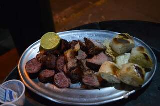 Prato com várias carnes, pão de alho, farofa e limão, que é servido nas mesas. (Foto: Bárbara Cavalcanti)