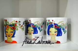 Canecas com a arte de Ana Zahran para compra na galeria. (Foto: Bárbara Cavalcanti)
