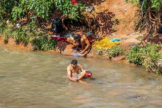 Homens tomam banho com água do Rio Anhandui, única fonte para higiene pessoal. (Foto: Paulo Francis)