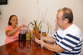 Neide e João mostram bebidas na fase inicial de preparação. (Foto: Kísie Ainoã)