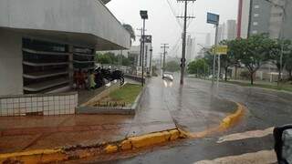 Motociclistas se protegem da chuva em Campo Grande. (Foto: Gabriela Couto)