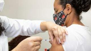 Mulher recebe dose de vacina contra covid em posto de saúde da Capital. (Foto: PMCG)