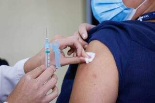 Moradora sendo vacinada na Capital. (Foto: Henrique Kawaminami) 