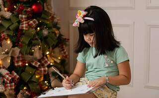 A pequena Laís pintando sua cartinha. (Foto: Mariana Jordão)