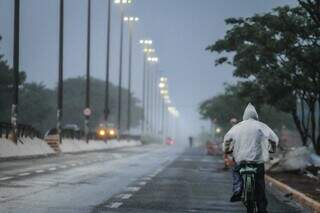 Ciclista usa capa para se proteger da chuva no início da manhã desta quinta. (Foto: Marcos Maluf)